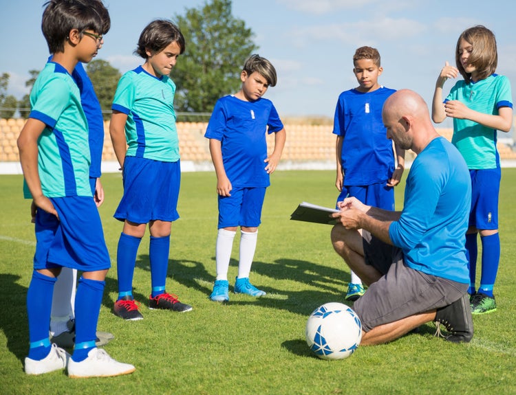 A volunteer youth sports coach with players